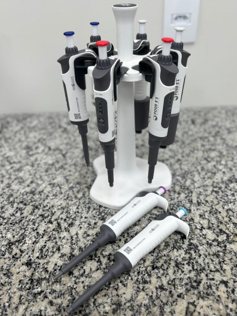Suporte carrossel com micropipetas monocanal organizadas sobre bancada de granito prontas para testes de calibração volumétrica.