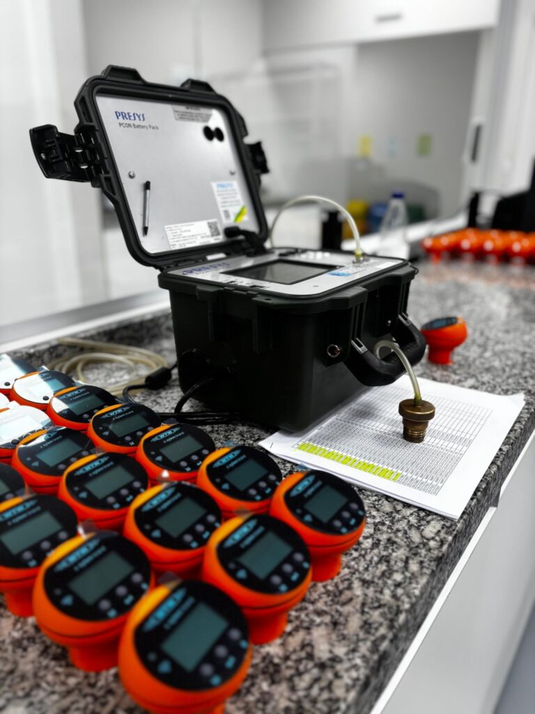 Calibrador portátil e sensores respirométricos de DBO sobre bancada durante processo de calibração de equipamentos de medição em laboratório.